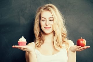 lady deciding between cupcake and apple