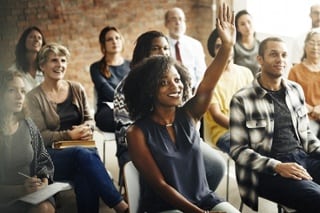 student raising her hand and in communication