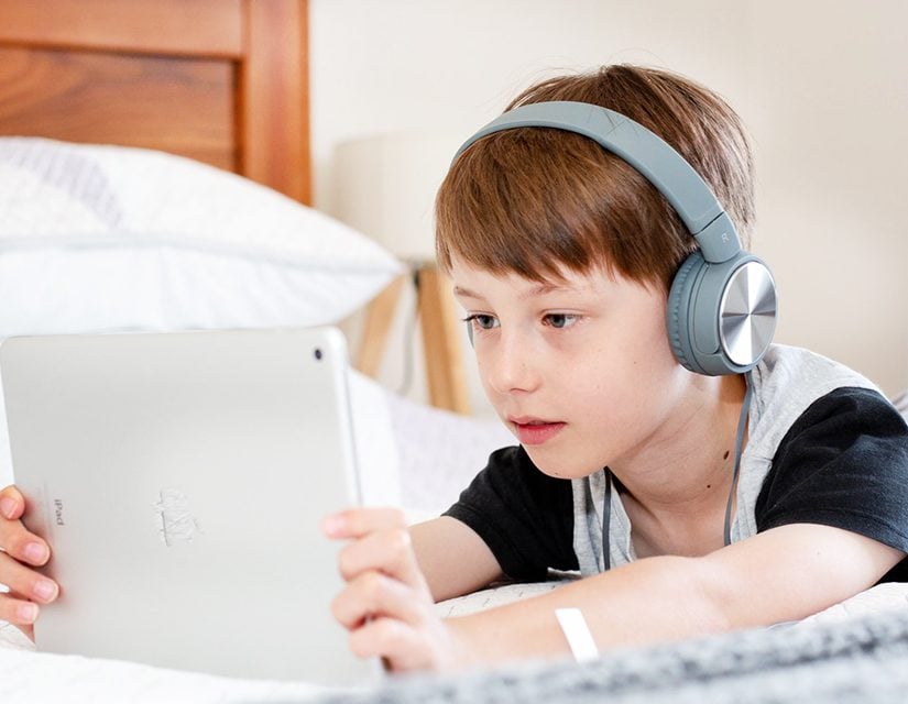 E-book reader used by kid with headphones